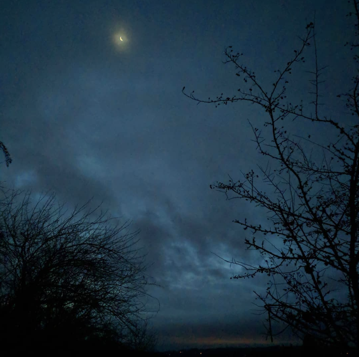 Waning crescent moon on a morning of flying clouds in early December