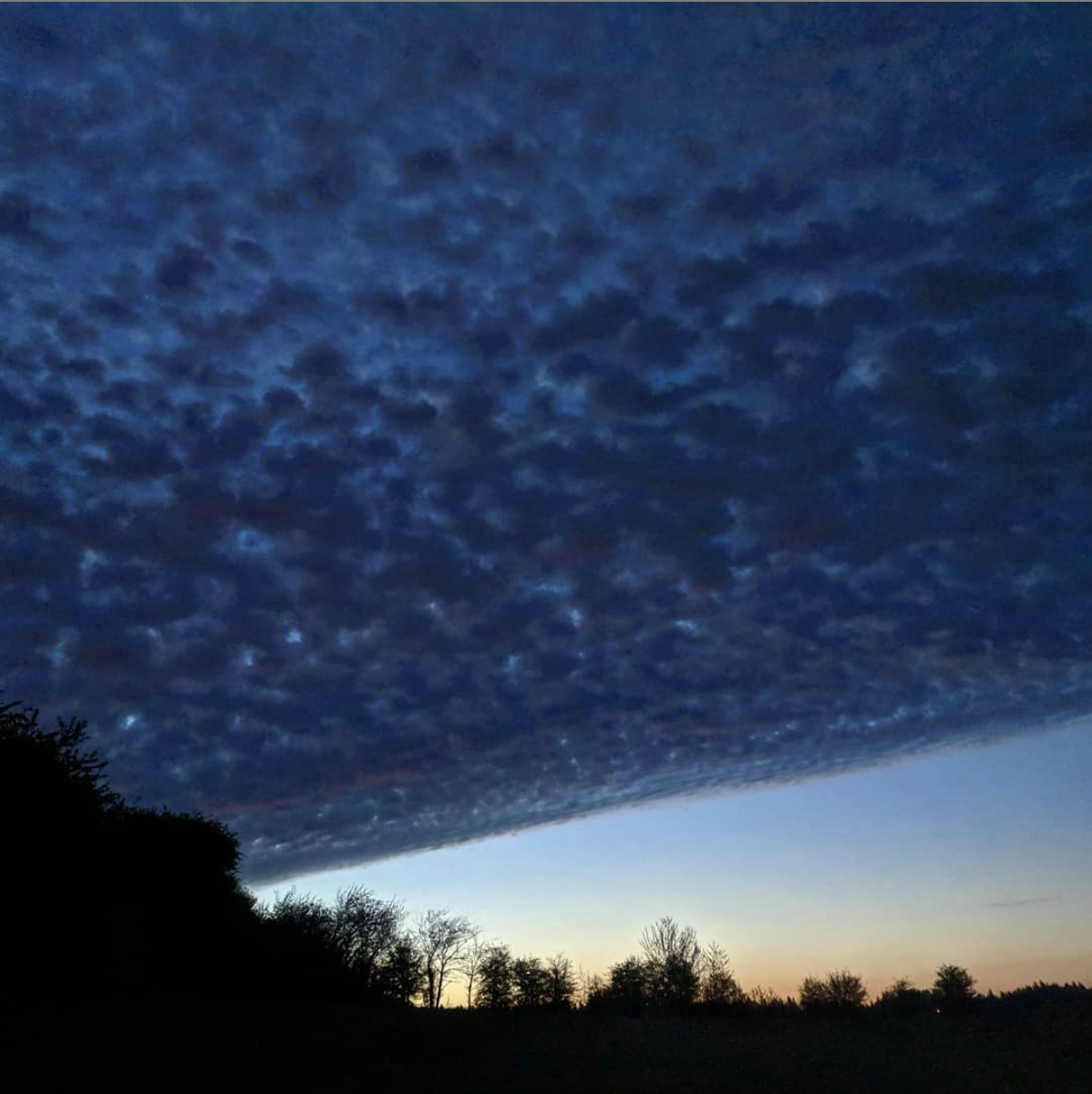 A diagonal veil of altocumulus divides day from night on a mid-April morning, just before sunrise. Photo copyright Tara K. Shepersky.